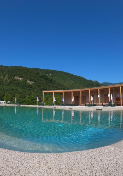 Piscina tranquilla con vista montagna e cielo azzurro limpido.